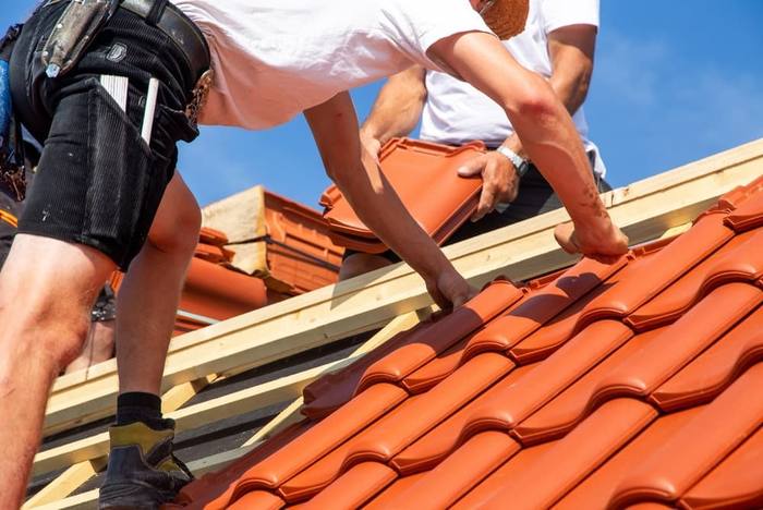 Roofers laying tile on a new roof
